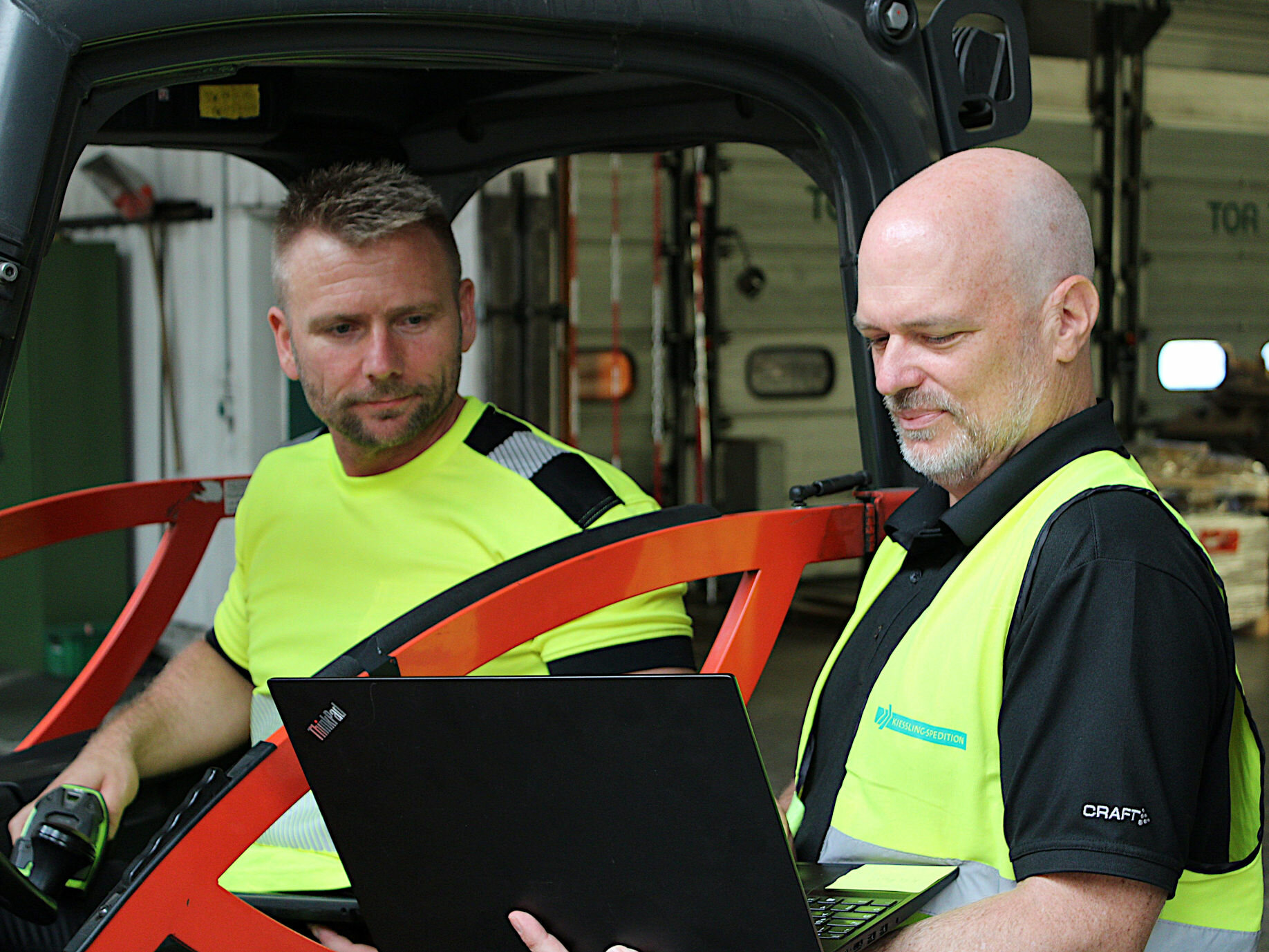 Workers from it and warehousing check the latest transport information on their computer