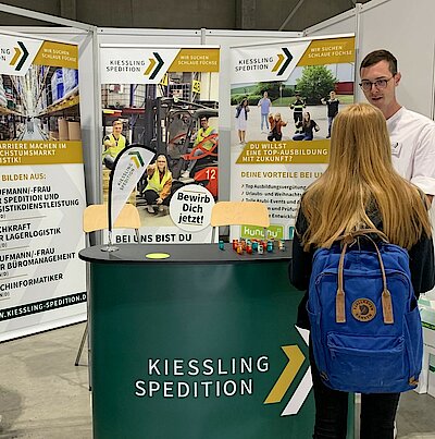 Gespräch zwischen einem Azubi der Kiessling-Spedition und einem Schüler auf einer Karrieremesse