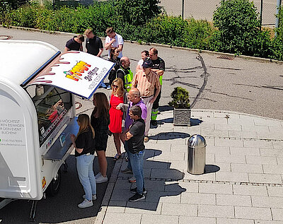 Schlange von Mitarbeitern vor dem Eiswagen
