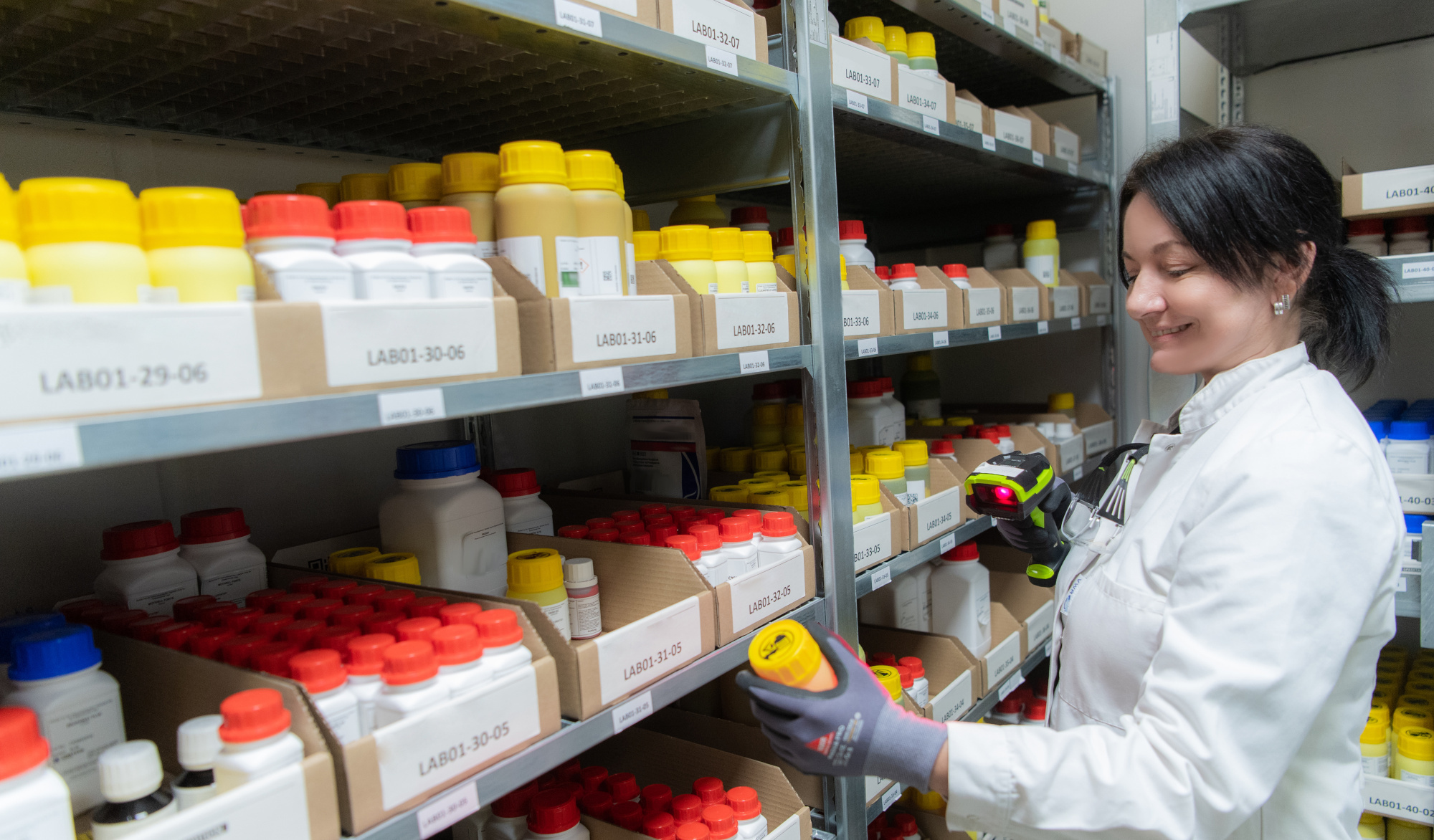 Mitarbeiterin des Labors scannt Produkte für Ab- und Umfüllarbeiten